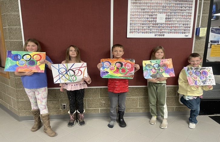 3rd grade students holding their Olympic paintings
