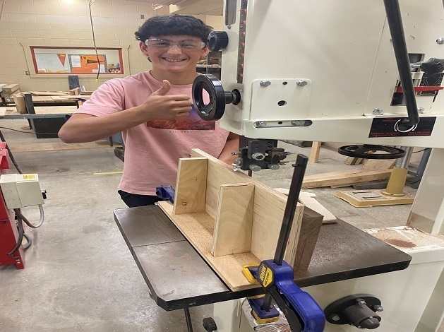 Student using a machine in woodshop class