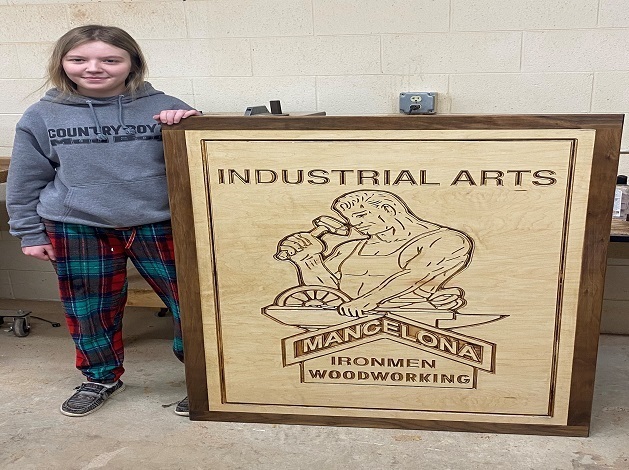 Girl displaying their industrial arts project