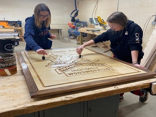 2 girls working on a woodshop project