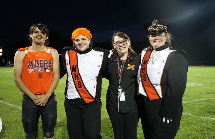 High School band students and director on the football field.
